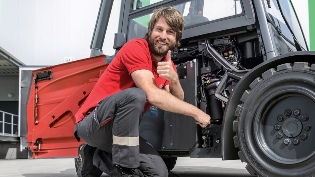 Serviser pregleda unutrašnje komponente električnog viljuškara Linde X20-X35 sa otvorenim bočnim panelom